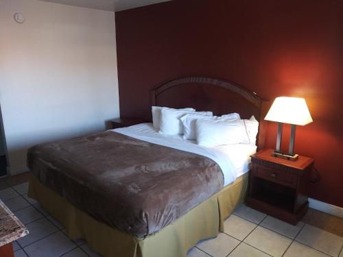 Bett in einem Hotelzimmer mit einer Lampe auf einem Tisch in der Unterkunft Red Apple Inn in Wayne