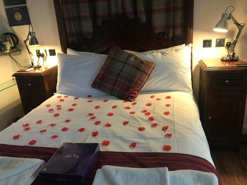 a bed with red roses on it with two lamps at Hot Tub Hide Away near Alton Towers staffordshire in Cheddleton