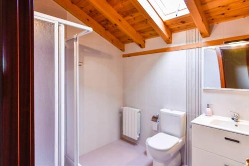 y baño con ducha, aseo y lavamanos. en Precioso apartamento reformado en Liencres en Liencres