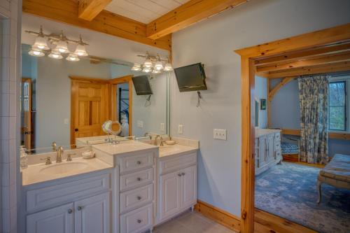 ein Badezimmer mit zwei Waschbecken und einem großen Spiegel in der Unterkunft Mountain Dream 3 Bed, Sauna, & Stunning Views in Mill Spring