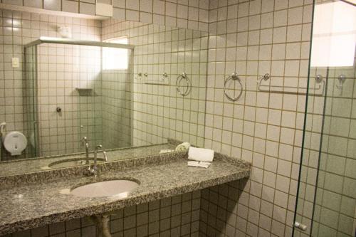 a bathroom with a sink and a mirror at Caruaru Pallace Hotel in Caruaru