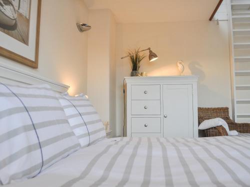 a bedroom with a white dresser and a bed at Starboard Light in Lymington