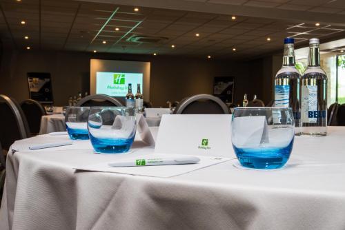 a table with two glasses and bottles of wine at Holiday Inn Lancaster by IHG in Lancaster