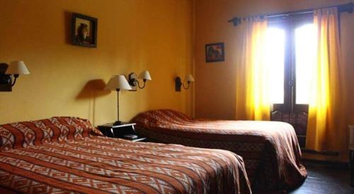 a hotel room with two beds and a window at HOSTERIA BUENAVISTA in Tafí del Valle