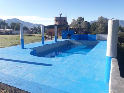 een blauw zwembad met een blauw dak bij HOSTERIA BUENAVISTA in Tafí del Valle