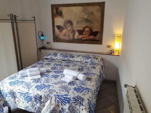 ein Schlafzimmer mit einem blauen und weißen Bett mit einem Bild an der Wand in der Unterkunft In Vacanza a Gaeta - MariStella in Gaeta