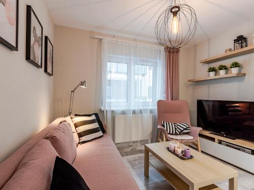 uma sala de estar com um sofá e uma televisão em VacationClub – Unieście-Szafirowa Mierzeja 9 em Mielno