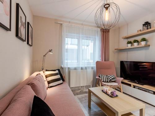 a living room with a couch and a tv at VacationClub – Unieście-Szafirowa Mierzeja 9 in Mielno