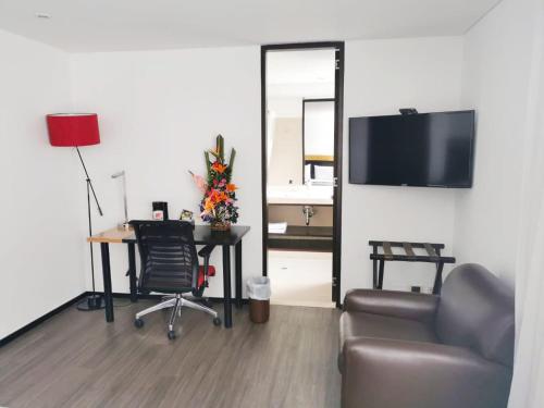 a living room with a couch and a table and a television at Hotel Madisson Inn Luxury By GEH Suites in Bogotá