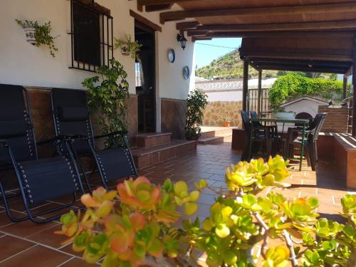 een patio met stoelen, een tafel en een tafel bij Casa cecilio in Nerja