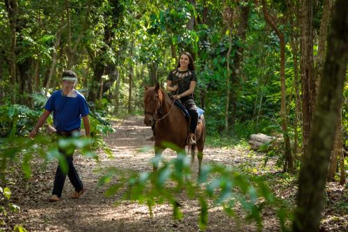 a man and a woman riding a horse in the woods at Canzi Cataratas Hotel in Foz do Iguaçu