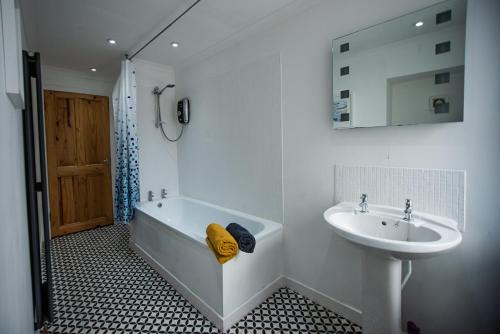 a bathroom with a sink and a bath tub and a sink at Fisherman Cottage in Wick