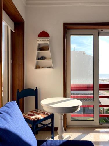 a room with a table and a view of the ocean at Terraços da Vagueira in Praia da Vagueira