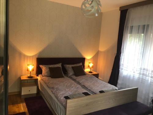 a bedroom with a large bed with two lamps at Porto23 in Belgrade
