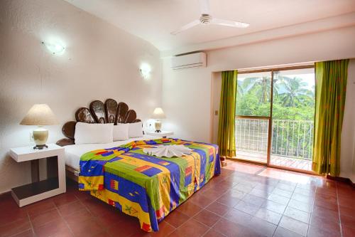 a bedroom with a large bed and a large window at Suites Plaza del Rio - Family Hotel Malec&oacute;n Centro in Puerto Vallarta
