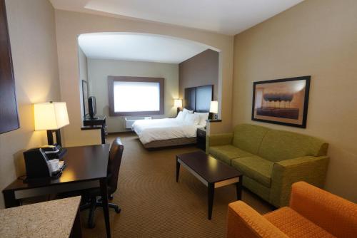 een hotelkamer met een bed en een bank bij Creekside Hotel & Suites in Canyonville