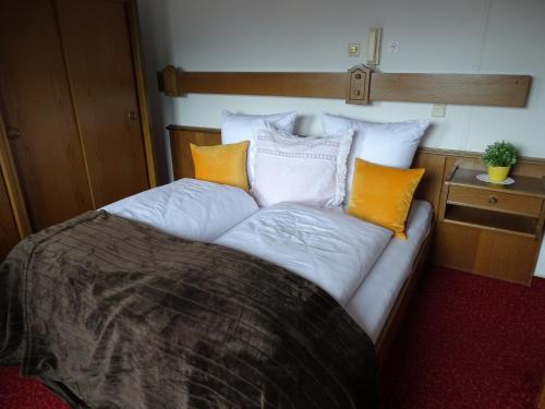 a bed with orange and white pillows in a room at Appartementhaus Kaltenbach-Stumm by PiaundDirk in Stumm