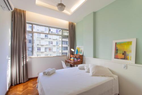 a bedroom with a white bed and a window at Apartamento 3 quartos Ipanema in Rio de Janeiro