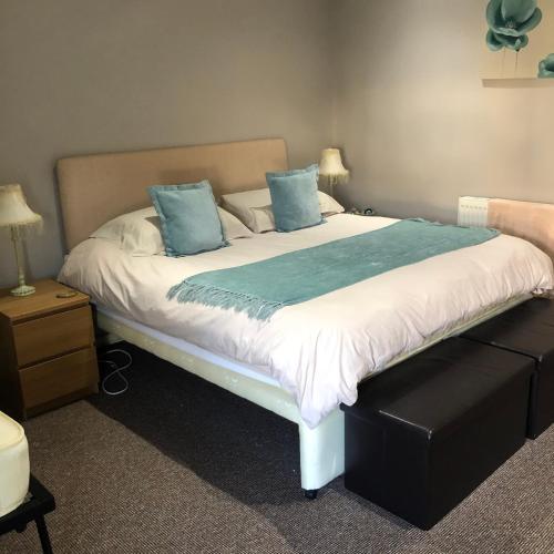 a bedroom with a large bed with blue pillows at The View in Grange Over Sands
