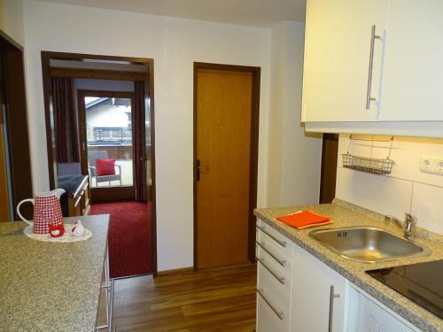 a kitchen with a sink and a door into a room at Appartementhaus Kaltenbach-Stumm by PiaundDirk in Stumm
