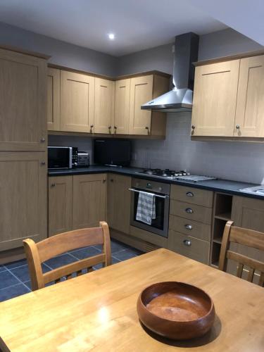 una cucina con tavolo in legno e ciotola di legno di The View a Grange Over Sands