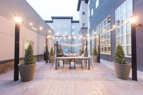 a patio with a table and chairs on a building at Staybridge Suites - Denver North - Thornton by IHG in Thornton