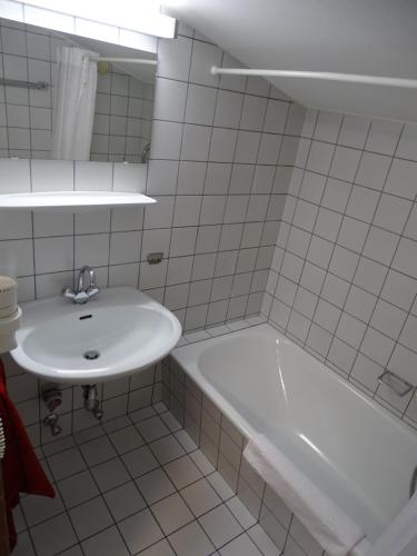a white bathroom with a sink and a bath tub at Appartementhaus Kaltenbach-Stumm by PiaundDirk in Stumm