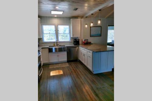 a kitchen with white cabinets and a blue island at One-of-a-kindBeach, Village, Dock & Private Pool! in Siesta Key