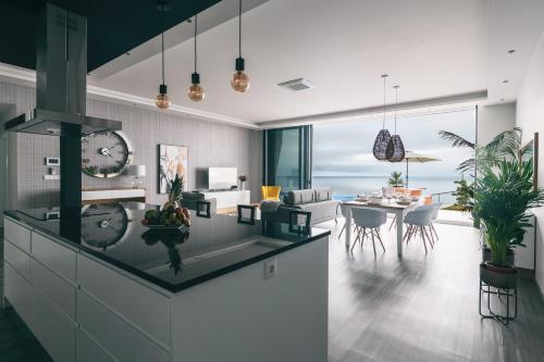 a kitchen and dining room with a clock on the counter at Villa Brava Atlântico in Ribeira Brava