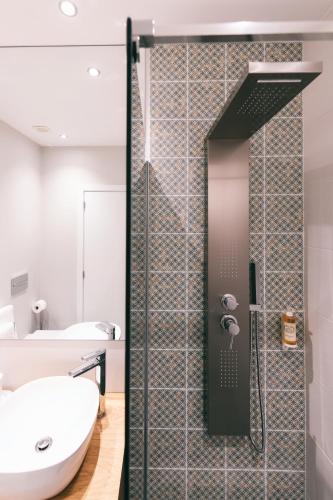 a bathroom with a shower and a white sink at Villa Brava Atlântico in Ribeira Brava