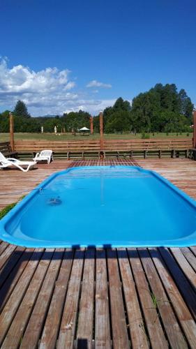 a large blue swimming pool on a wooden deck at Parques de Afunalhue in Licán Ray