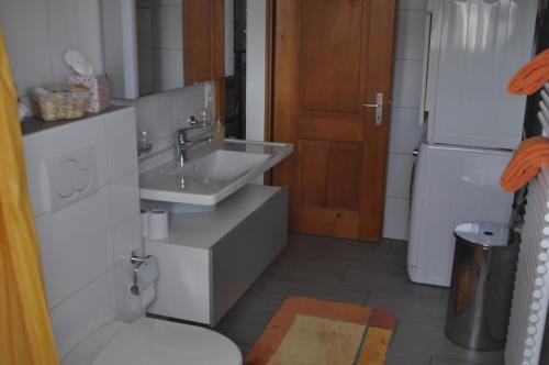 uma pequena casa de banho com um lavatório e um frigorífico em Ruhe pur em Aeschi bei Spiez