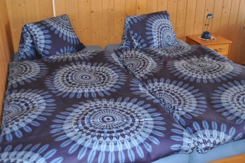 ein Bett mit einer Bettdecke und Kissen darauf in der Unterkunft Ruhe pur in Aeschi bei Spiez