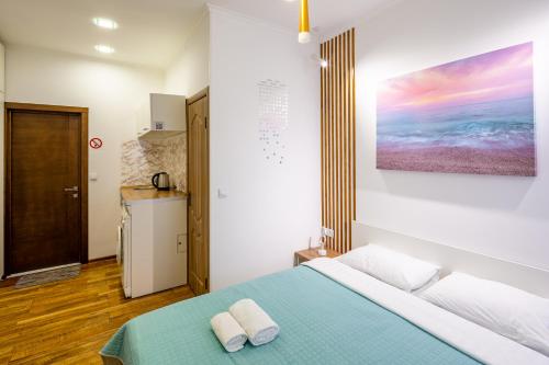 a bedroom with a bed with two towels on it at Cozy apartments center in Lviv