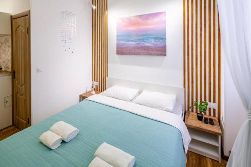 a bedroom with a blue bed with two pillows at Cozy apartments center in Lviv