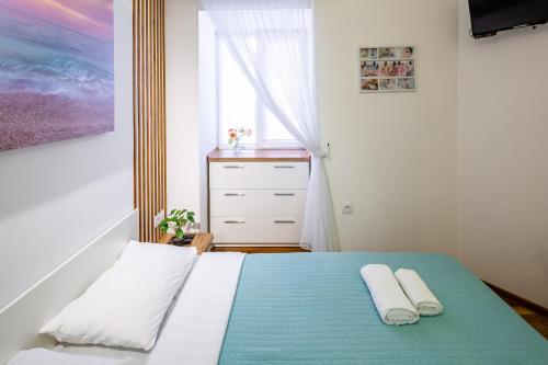 a bedroom with a bed with two towels on it at Cozy apartments center in Lviv