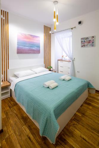 a bedroom with a large bed with a green blanket at Cozy apartments center in Lviv