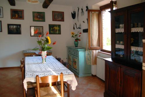 a dining room with a table with a vase of flowers on it at La Capannella in Gallicano
