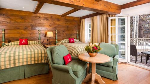 a bedroom with two beds and a table and chairs at Sonnenalp in Vail