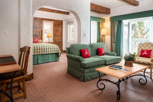 a living room with a green couch and a bed at Sonnenalp in Vail