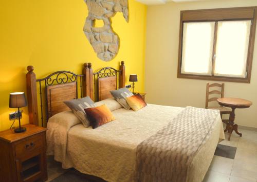 a bedroom with a large bed with yellow walls at Iturritxo Landetxea in San Sebastián