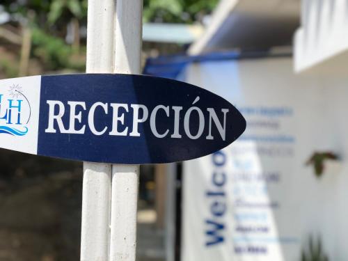 a blue and white sign on a white pole at L'Vanna Hotel in Pedernales