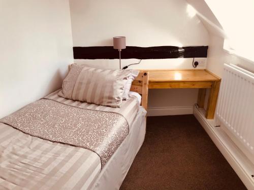 a small bedroom with a bed and a desk at Severn Valley Guest House in Bewdley