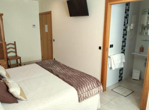 a bedroom with a bed and a tv on the wall at Iturritxo Landetxea in Donostia-San Sebastián