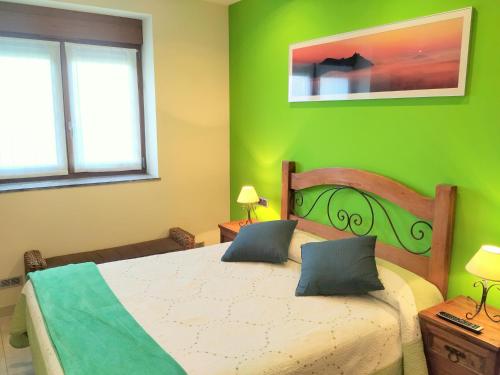 a bedroom with a large bed with green walls at Iturritxo Landetxea in Donostia-San Sebastián