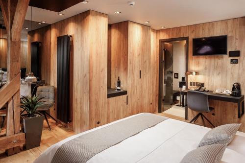 a bedroom with wooden walls and a bed and a desk at SCHUSTER Boarding House in Braşov