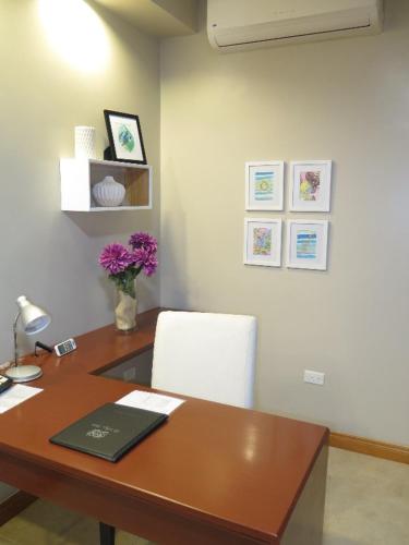 an office with a desk with a chair and flowers at Le Plaza Hotel in Port-au-Prince