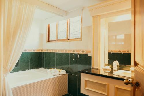 La salle de bains est pourvue d'une baignoire, d'un lavabo et d'un miroir. dans l'établissement El Rodeo Estancia Boutique Hotel & Steakhouse, à San José