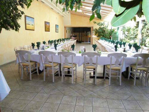 a row of tables and chairs with white table cloth at Weinhotel Kirchenwirt in Gols