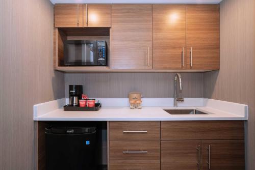 a kitchen with a sink and a microwave at Sandman Signature Calgary Downtown Hotel in Calgary